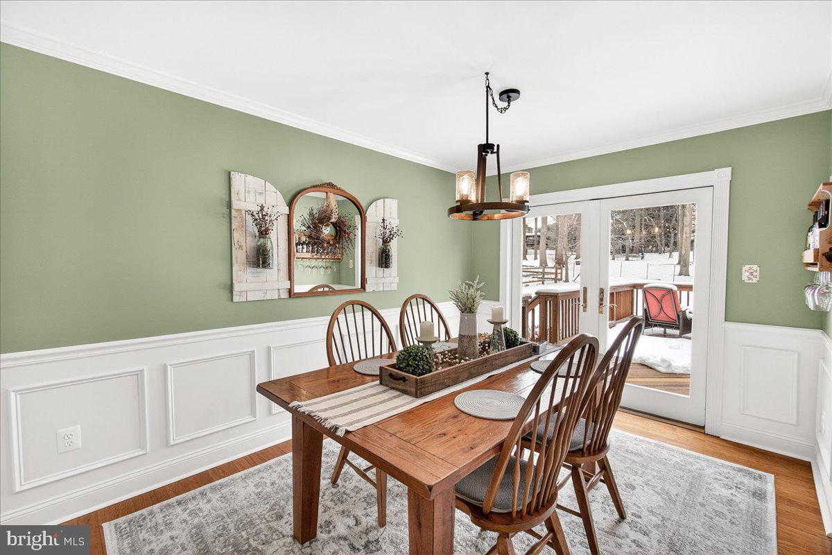 24013 Bush Hill Road Gaithersburg, MD 20882 - Photo 11 of 38 a dining room with furniture wooden floor a rug and a chandelier