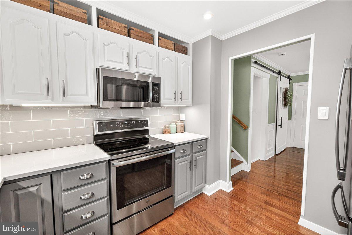 24013 Bush Hill Road Gaithersburg, MD 20882 - Photo 12 of 38 a kitchen with cabinets stainless steel appliances and wooden floor