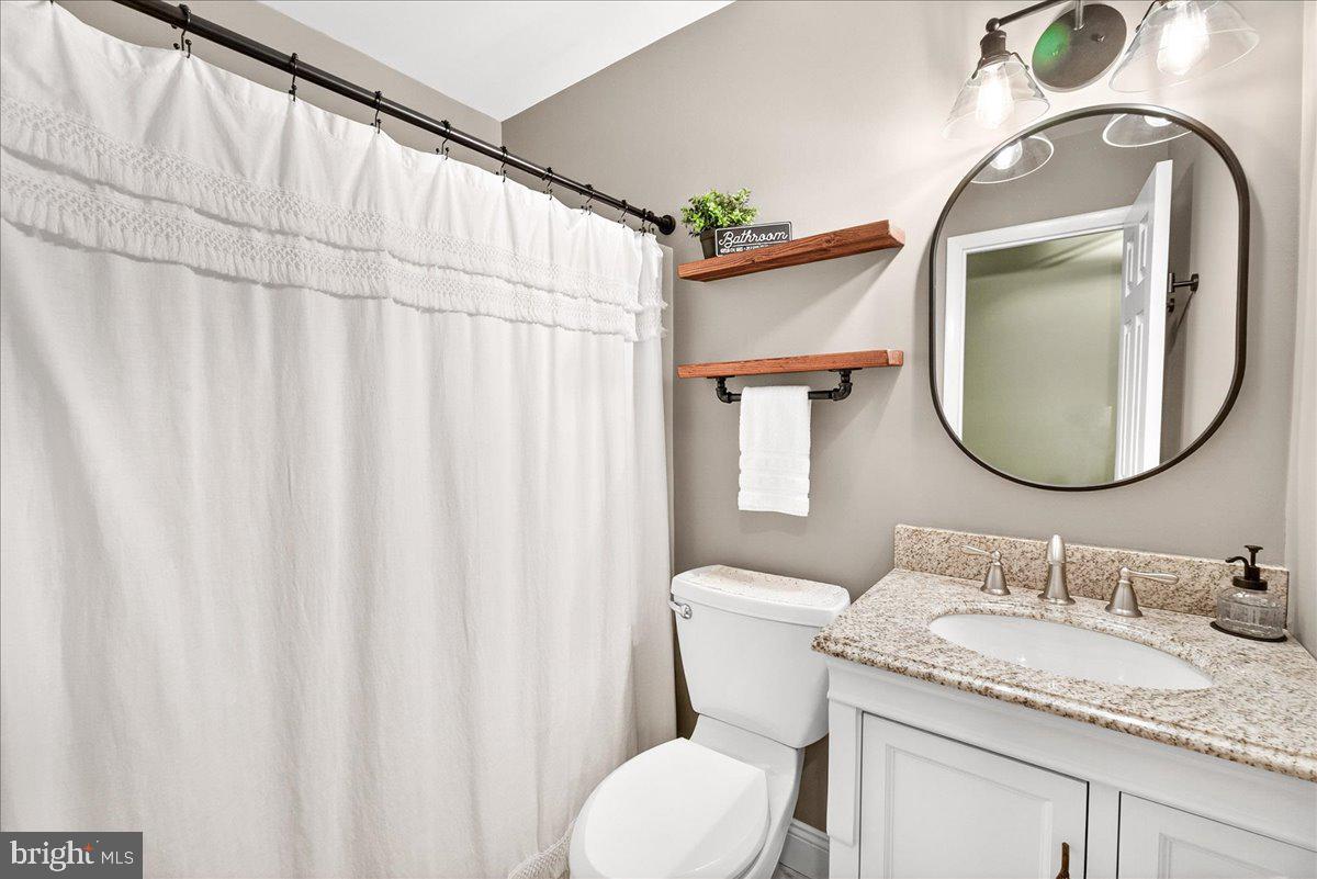 24013 Bush Hill Road Gaithersburg, MD 20882 - Photo 21 of 38 a bathroom with a granite countertop sink vanity mirror and a toilet