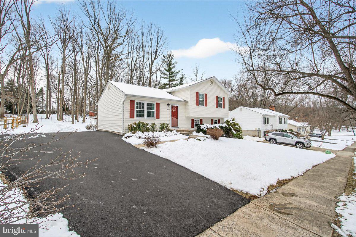24013 Bush Hill Road Gaithersburg, MD 20882 - Photo 4 of 38 a front view of a house with a yard covered in snow