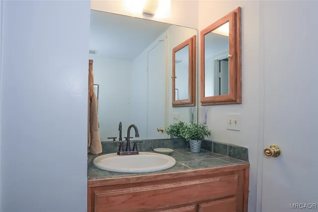a bathroom with a granite countertop sink a toilet and a mirror