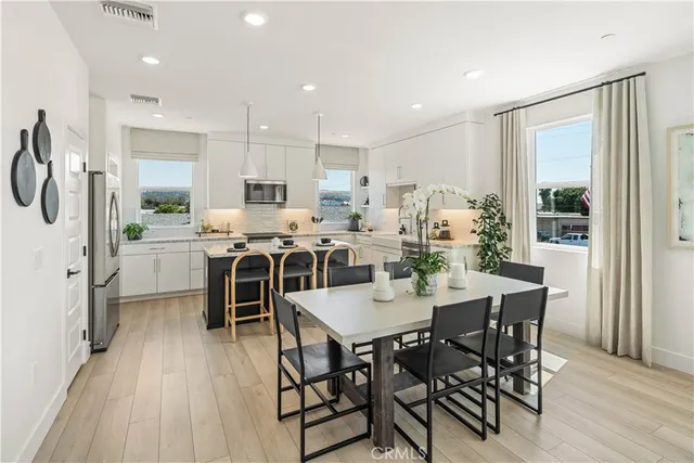 a large kitchen with dining room and wooden floor