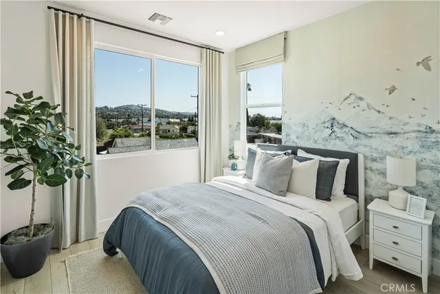 a bedroom with a large bed and a potted plant