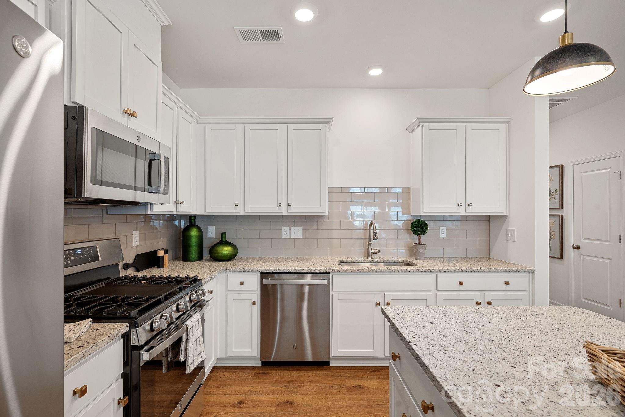 3579 Nimbell Road Monroe, NC 28110 - Photo 8 of 24 a kitchen with stainless steel appliances granite countertop a stove top oven a sink a microwave and cabinets