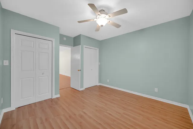 a view of a big room with wooden floor and a ceiling fan