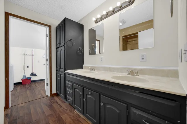 a bathroom with a granite countertop sink a mirror and a shower