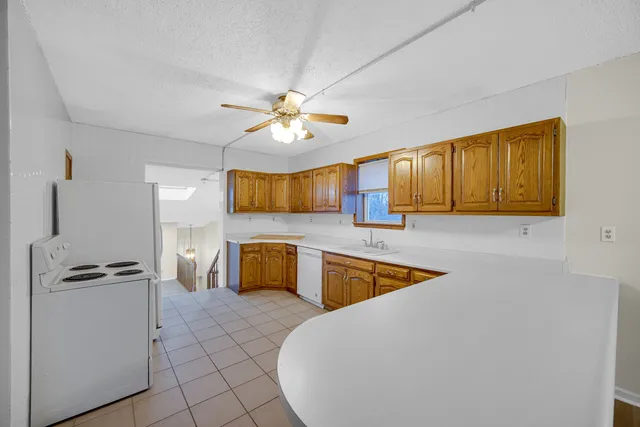 a large white kitchen with a stove a sink and dishwasher