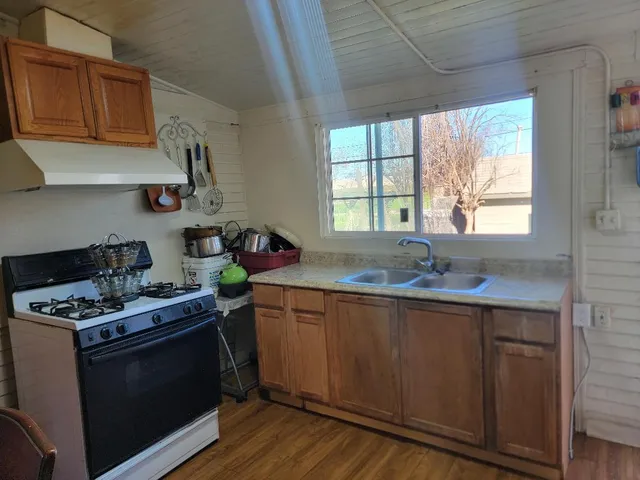 a kitchen with stainless steel appliances a sink a stove and wooden cabinets