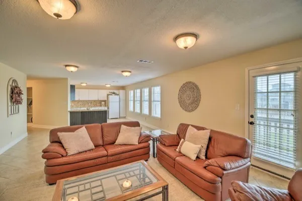 a living room with furniture ceiling fan and a window