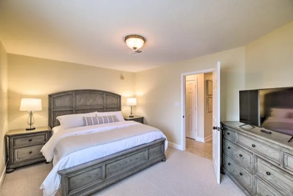 a bedroom with a large bed and flat tv screen on dresser