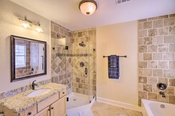 a bathroom with a tub sink and mirror