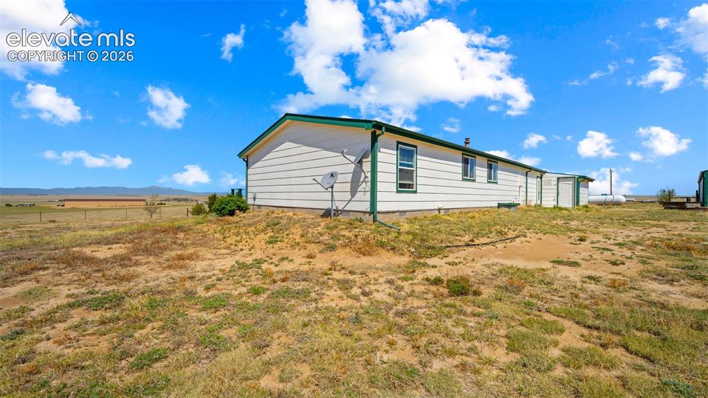 33975 Highway 94 Yoder, CO 80864 - Photo 26 of 40 White siding exterior with a contrasting green trim and multiple windows