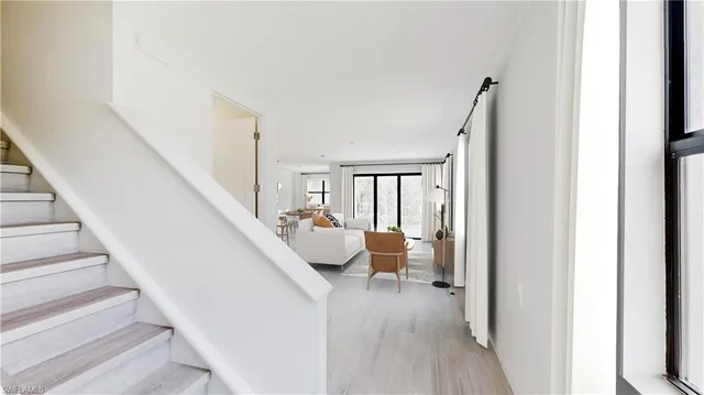 a hallway with wooden floor and furniture