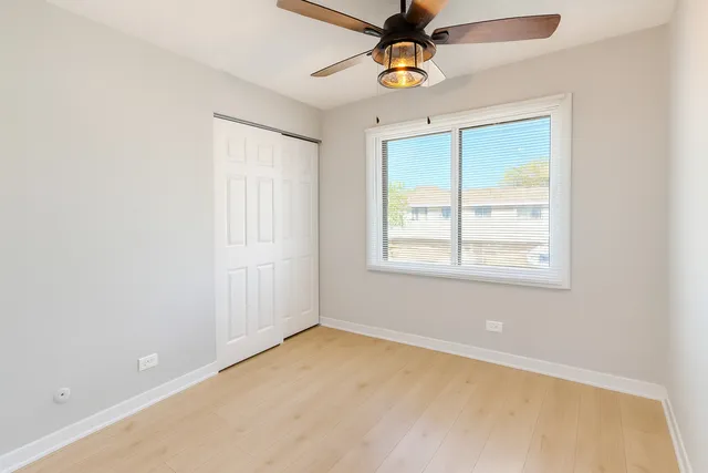 an empty room with a window and a fan