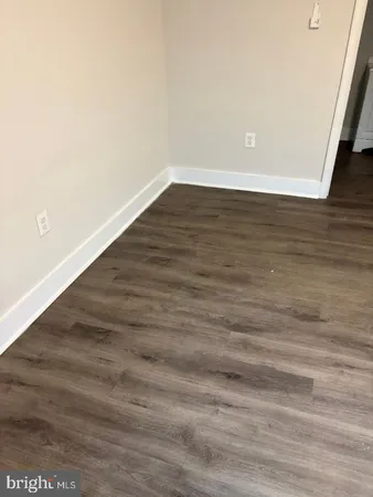 an empty room with wooden floor and entrance