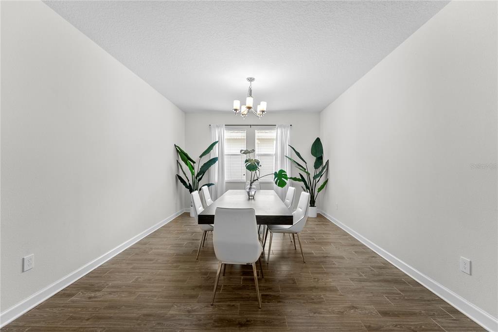 2926 Wordsmith Road Kissimmee, FL 34746 - Photo 13 of 42 a view of a dining room with furniture and wooden floor