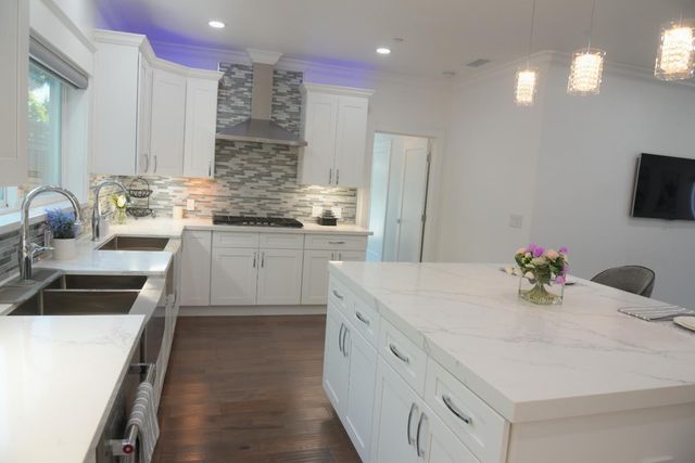 a sink with a granite countertop window and a sink