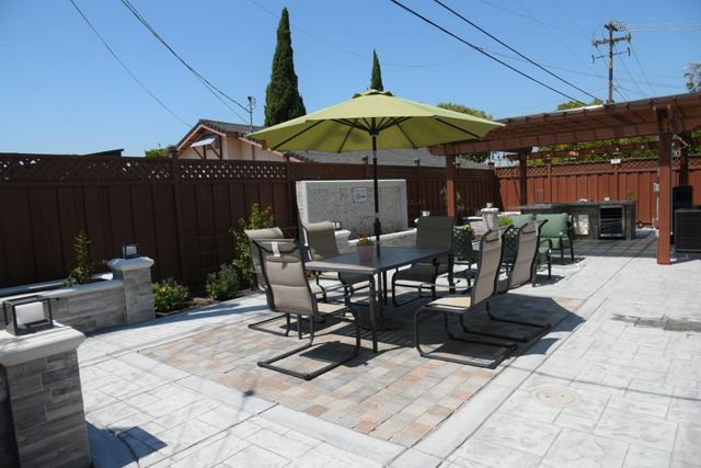 a view of a patio with a dining table and chairs under an umbrella