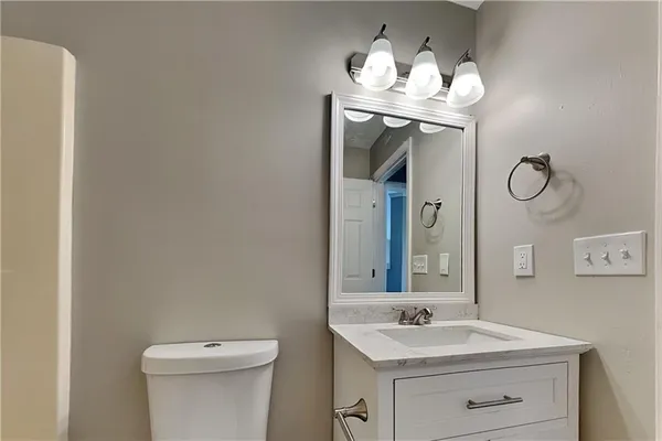 a bathroom with a toilet sink and mirror