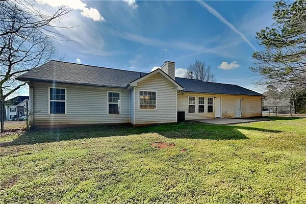 a view of a yard in front of a house with plants and large tree