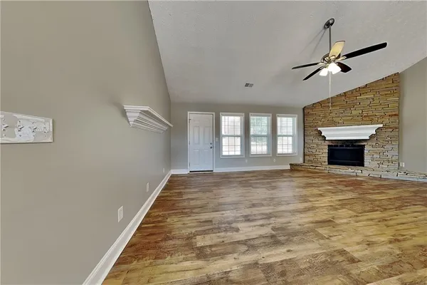 a view of an empty room with a fireplace and a window