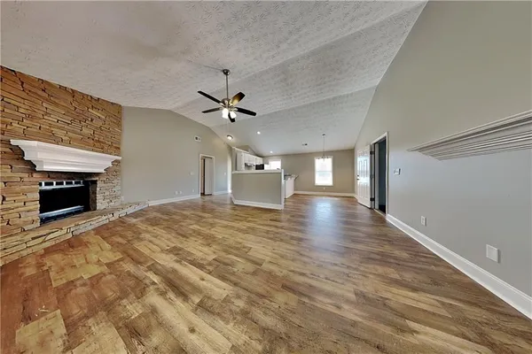a view of empty room with wooden floor and fireplace