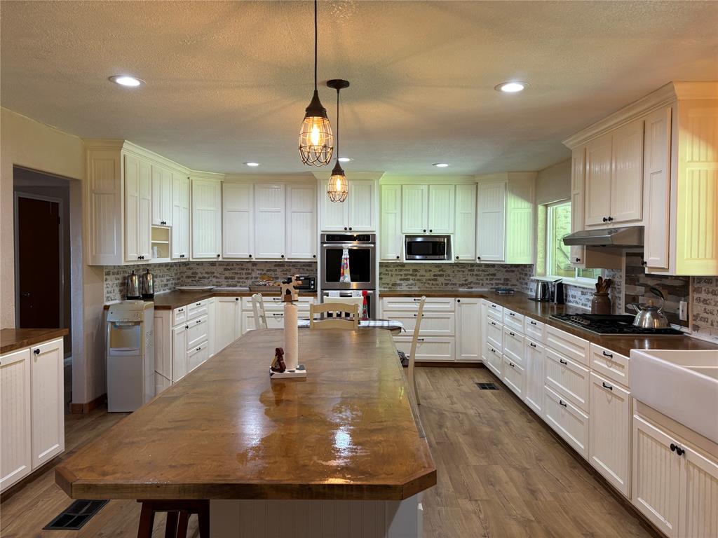 5355 Banks Road Fort Worth, TX 76140 - Photo 16 of 24 a large kitchen with kitchen island a large counter space a sink appliances and cabinets