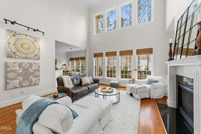 a kitchen with stainless steel appliances granite countertop a dining table chairs and white cabinets