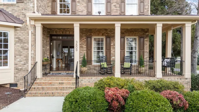 an empty room with chandelier fan and wooden floor
