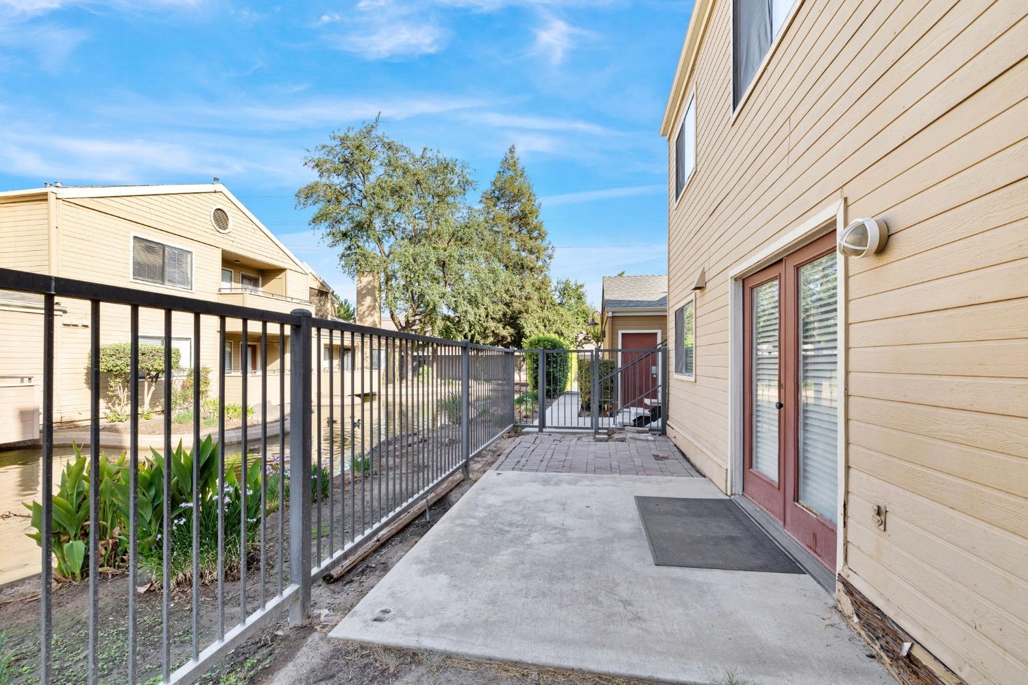 7675 North First Street, Unit 136 Fresno, CA 93720 - Photo 22 of 40 a view of a porch with a floor to ceiling window and wooden fence