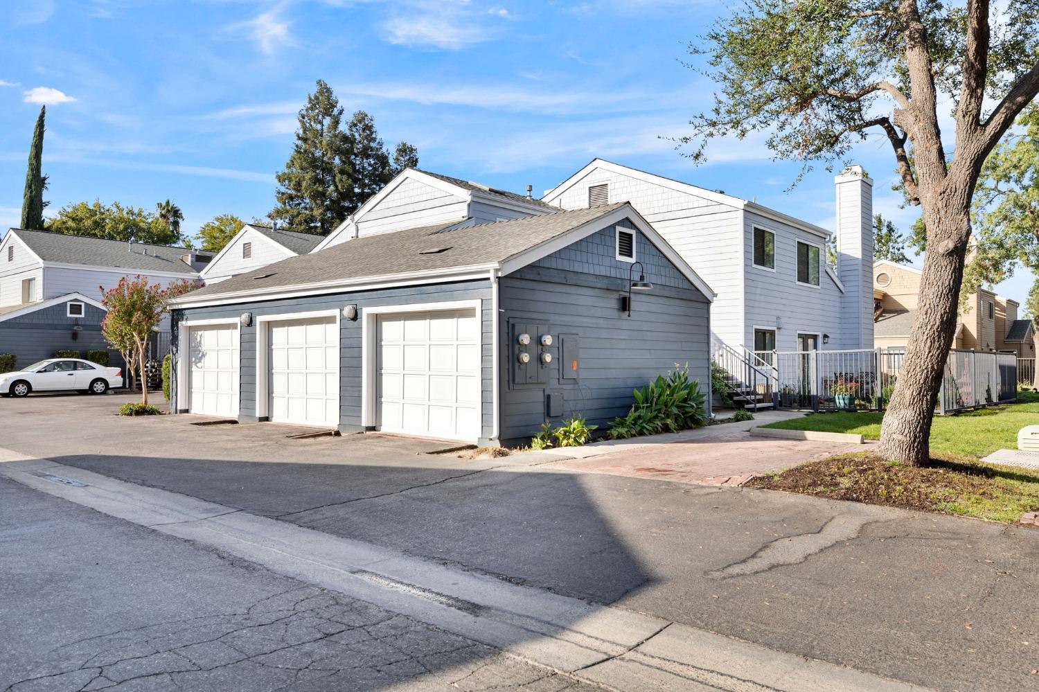 7675 North First Street, Unit 136 Fresno, CA 93720 - Photo 25 of 40 a front view of a house with a yard and garage