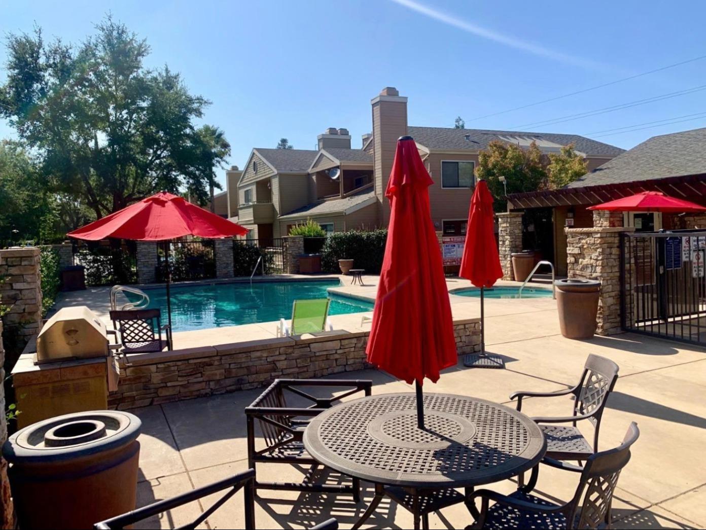 7675 North First Street, Unit 136 Fresno, CA 93720 - Photo 40 of 40 a patio with a table and chairs under an umbrella