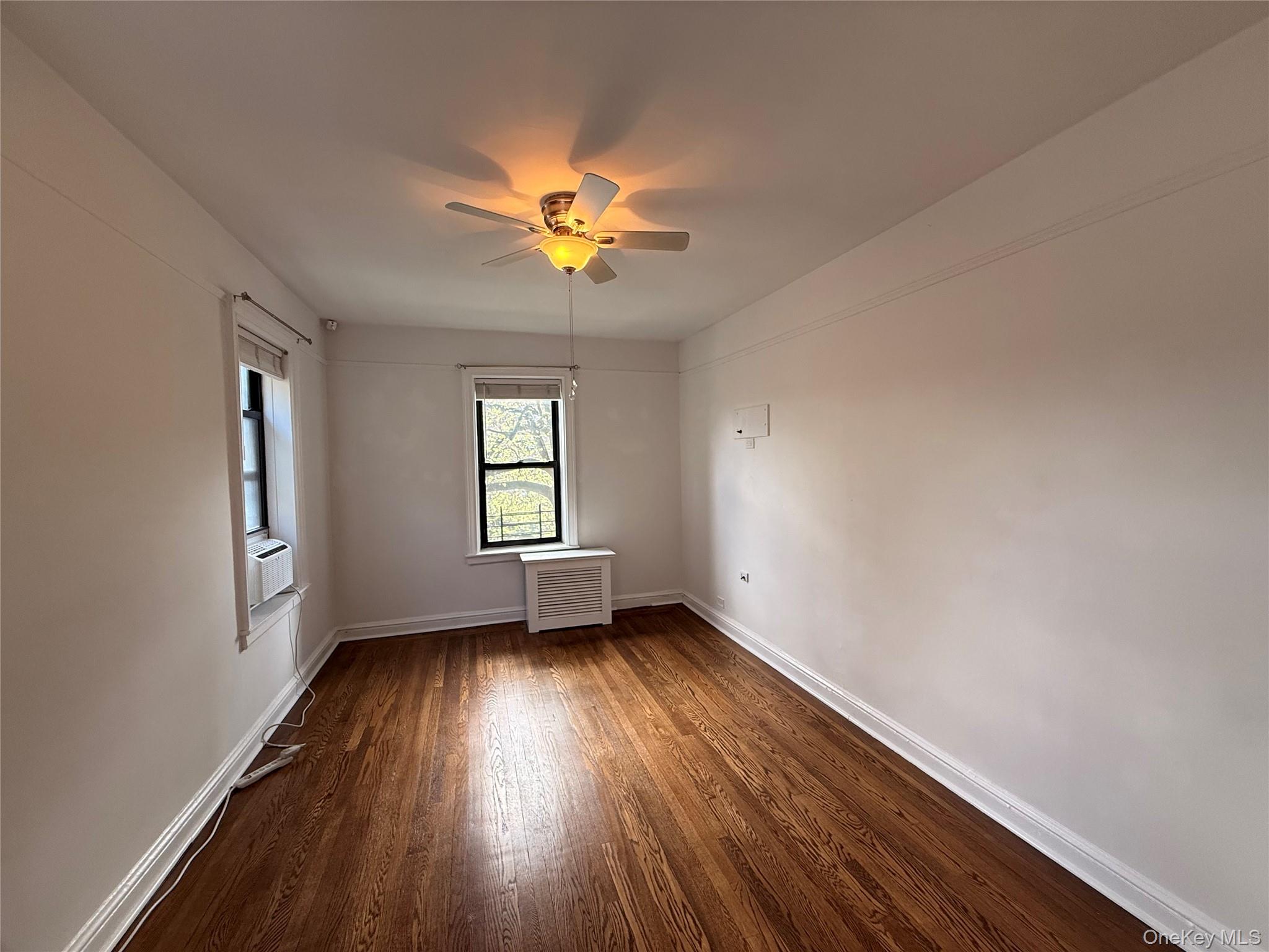 143 Garth Road, Unit 3L Scarsdale, NY 10583 - Photo 18 of 37 This room features hardwood floors, white walls, and a ceiling fan with integrated lighting