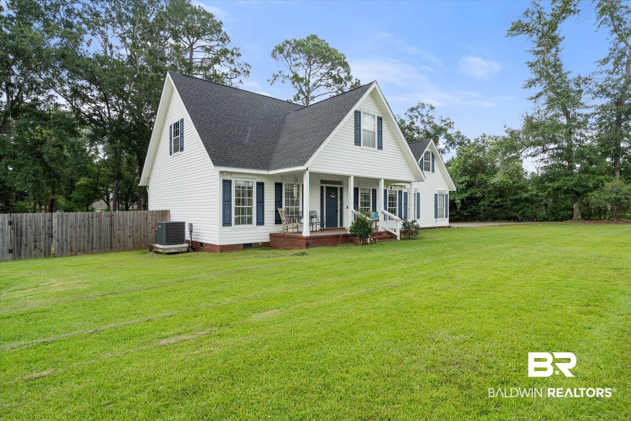 22760 Ridgewood Drive Robertsdale, AL 36567 - Photo 28 of 44 View of front facade featuring a shingled roof, a porch, crawl space, and view of scattered trees