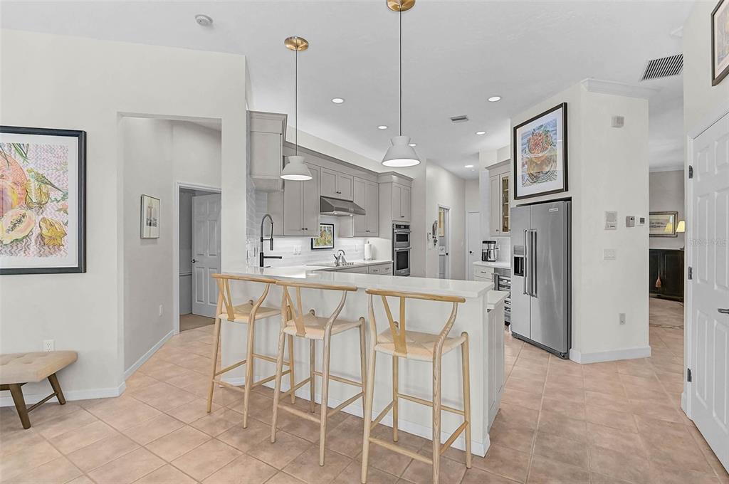 2050 Timucua Trail Nokomis, FL 34275 - Photo 13 of 50 a kitchen with stainless steel appliances kitchen island granite countertop a refrigerator a sink a stove and white cabinets