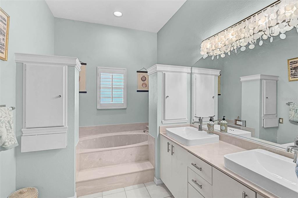 2050 Timucua Trail Nokomis, FL 34275 - Photo 24 of 50 a bathroom with a double vanity sink a mirror a bathtub and shower