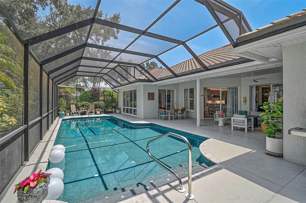 2050 Timucua Trail Nokomis, FL 34275 - Photo 39 of 50 a view of a patio with table and chairs potted plants with wooden floor and fence