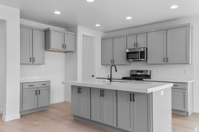 1869 South 2425 West Ogden, UT 84401 - Photo 12 of 22 Kitchen with gray cabinetry, tasteful backsplash, stainless steel appliances, light wood-type flooring, and recessed lighting