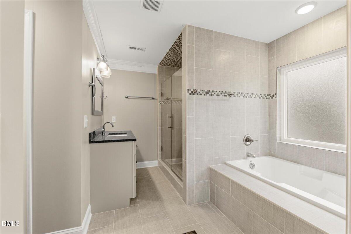 2402 Green Street Durham, NC 27705 - Photo 14 of 25 a bathroom with a tub a sink and a mirror