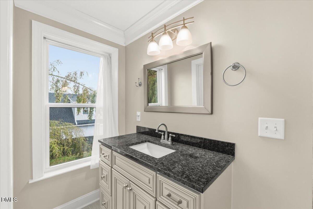 2402 Green Street Durham, NC 27705 - Photo 16 of 25 a bathroom with a granite countertop sink and a mirror