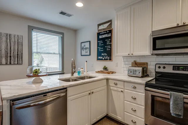 a kitchen with stainless steel appliances white cabinets and a sink