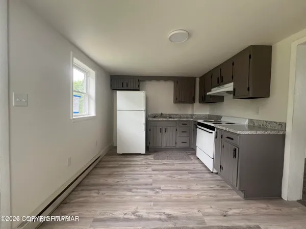 a kitchen with stove cabinets and refrigerator