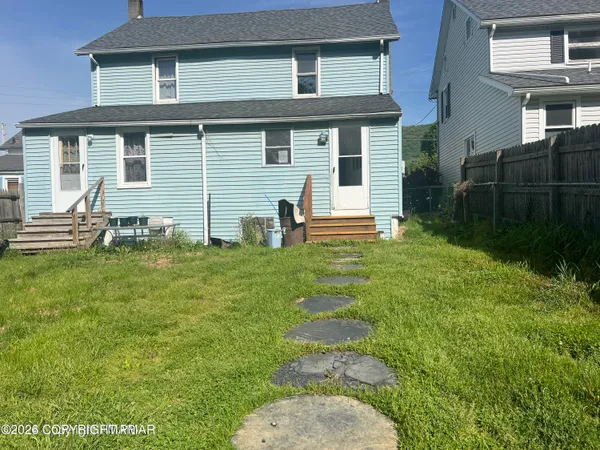a backyard of a house with table and chairs