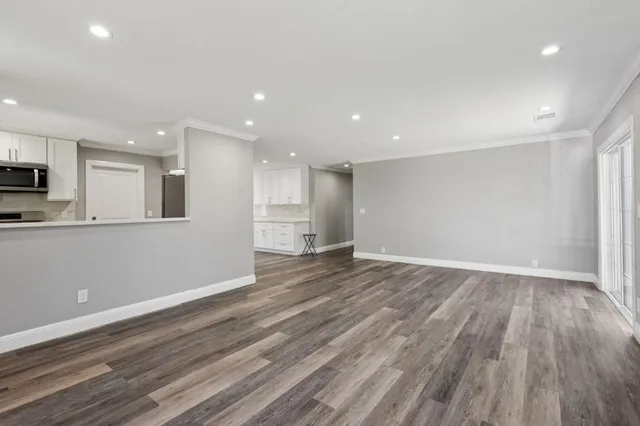 a view of empty room with wooden floor and windows