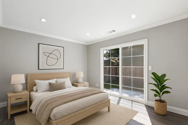a bedroom with a large bed and a potted plant