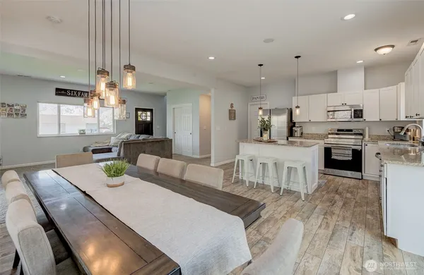 a large kitchen with kitchen island a stove a sink a dining table and chairs