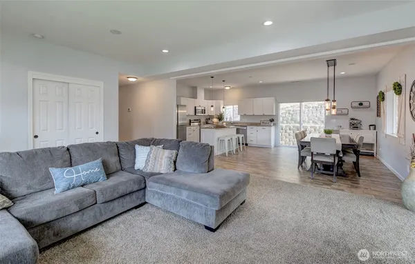 a living room with furniture and view of kitchen