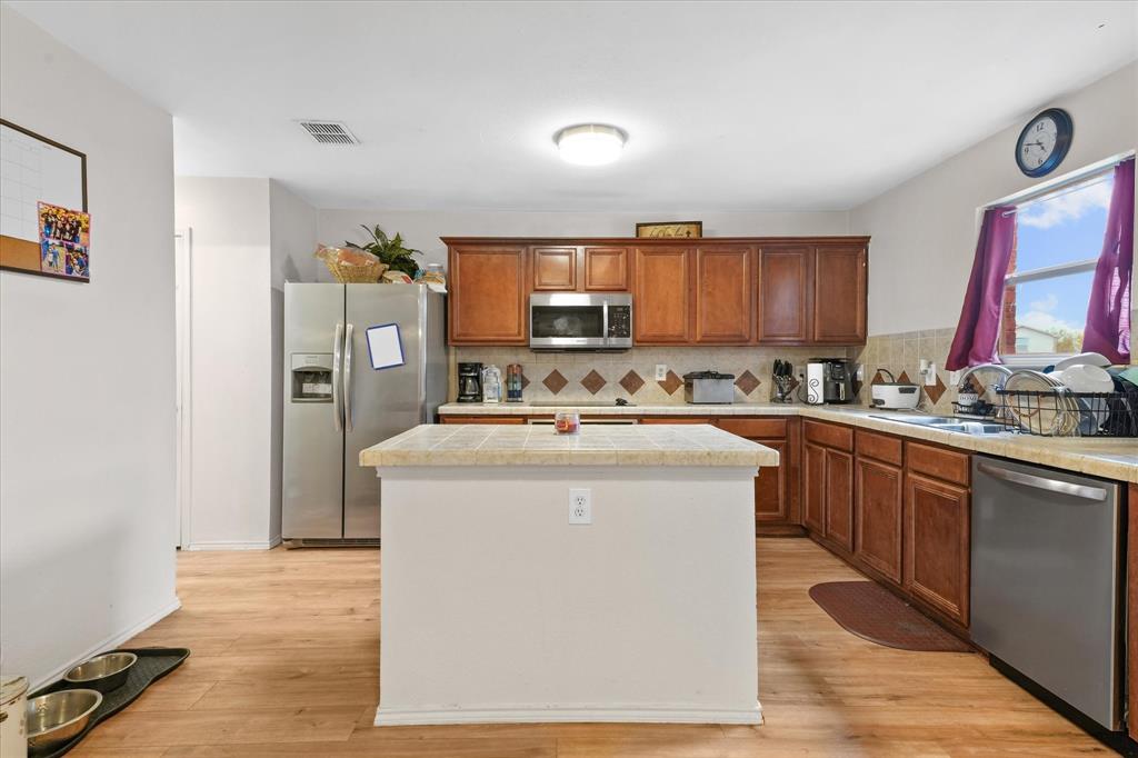 6725 Prairie Fire Road Arlington, TX 76002 - Photo 11 of 31 a kitchen with stainless steel appliances granite countertop a stove top oven a sink and a refrigerator