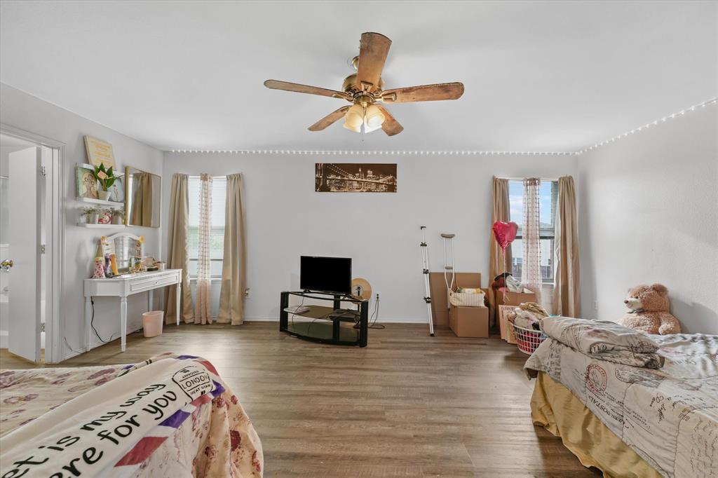 6725 Prairie Fire Road Arlington, TX 76002 - Photo 17 of 31 a bedroom with a bed and wooden floor