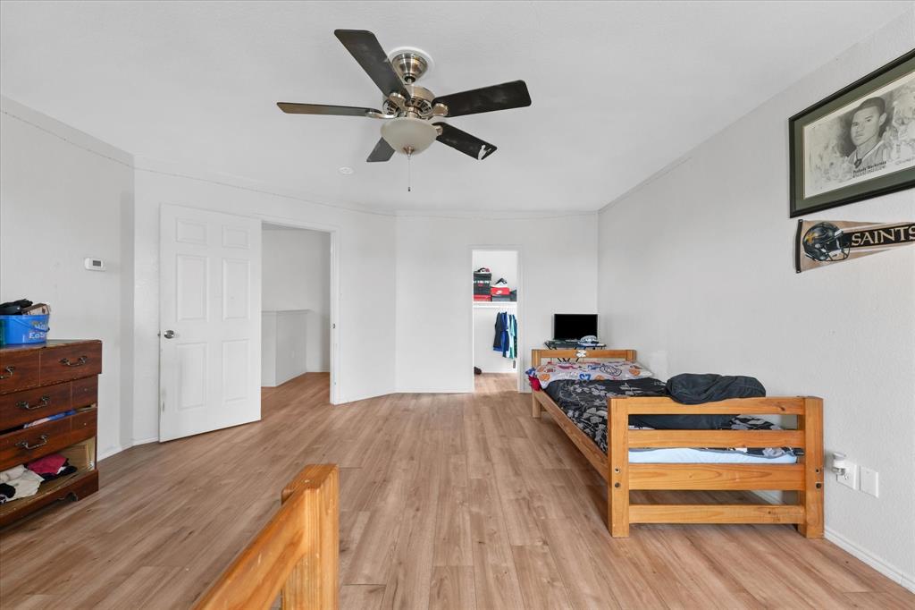 6725 Prairie Fire Road Arlington, TX 76002 - Photo 21 of 31 a bedroom with a bed and wooden floor
